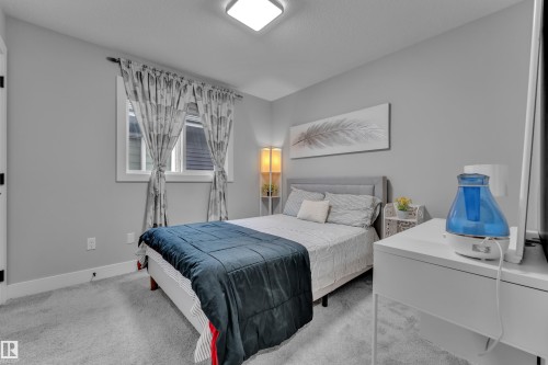 Bedroom featuring light gray wall paint, light gray carpeting, and a white window frame - 8025 174A Avenue, Edmonton, AB - Indoor Photo Showing Bedroom