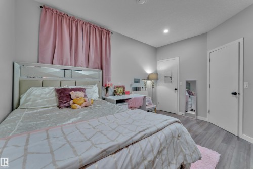 Grey wood-finish flooring complements the neutral wall color in this room - 8025 174A Avenue, Edmonton, AB - Indoor Photo Showing Bedroom