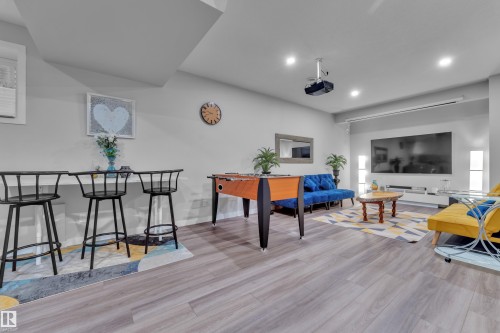 Finished interior room featuring recessed lighting, projector, projector screen, and wood-finish flooring - 8025 174A Avenue, Edmonton, AB - Indoor