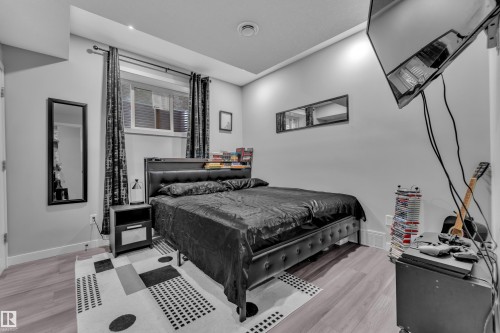 Bedroom featuring wood-finish flooring, recessed ceiling lighting, and a window with horizontal blinds - 8025 174A Avenue, Edmonton, AB - Indoor Photo Showing Bedroom