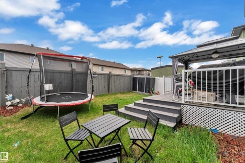Expansive backyard space featuring a multi-tiered deck with white railings, a covered gazebo, and a perimeter privacy fence - 8025 174A Avenue, Edmonton, AB - Outdoor With Deck Patio Veranda
