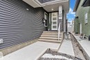 Contemporary exterior featuring dark gray siding and a white entry door with frosted glass panels - 8025 174A Avenue, Edmonton, AB  - Outdoor 
