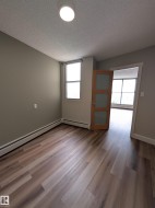 Room featuring wood-finish flooring, neutral wall paint, and a textured ceiling - 