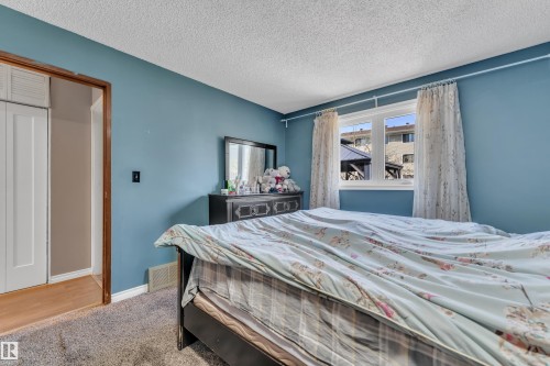 Bedroom featuring a window with white trim, light blue walls, and textured carpeting - 4536 35A Avenue, Edmonton, AB - Indoor Photo Showing Bedroom