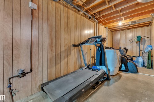 Finished basement area featuring wood paneling, exposed ceiling joists, and concrete flooring - 4536 35A Avenue, Edmonton, AB - Indoor Photo Showing Gym Room