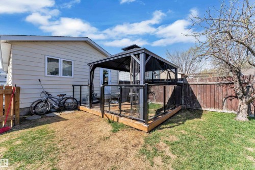 Rear yard featuring a wood deck with glass panel railing and a built-in gazebo - 4536 35A Avenue, Edmonton, AB - Outdoor