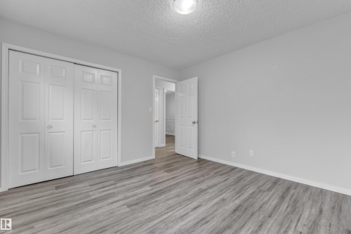 Room featuring wood-finish flooring, light grey walls, and white trim - 2119 85 Street, Edmonton, AB - Indoor Photo Showing Other Room