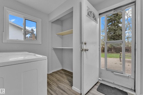 Entryway featuring a white paneled door with an arched transom window, a full-light storm door, and wood-finish flooring - 2119 85 Street, Edmonton, AB - Indoor