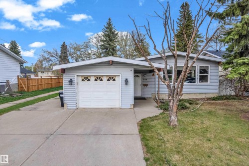 Light blue siding exterior featuring a white garage door with decorative window inserts - 2119 85 Street, Edmonton, AB - Outdoor