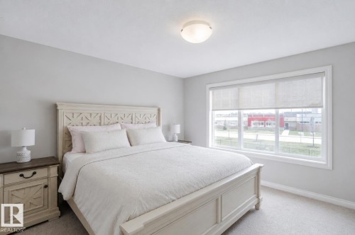 Light-filled room featuring a broad window with white trim, roller shades, and plush carpeting - 328 West Haven Drive, Leduc, AB - Indoor Photo Showing Bedroom