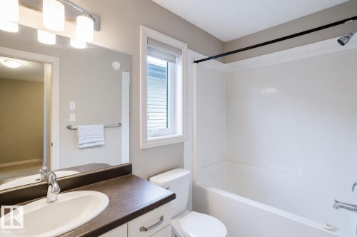 Bathroom featuring a white vanity with a dark countertop, an integrated sink, and chrome fixtures - 328 West Haven Drive, Leduc, AB - Indoor Photo Showing Bathroom