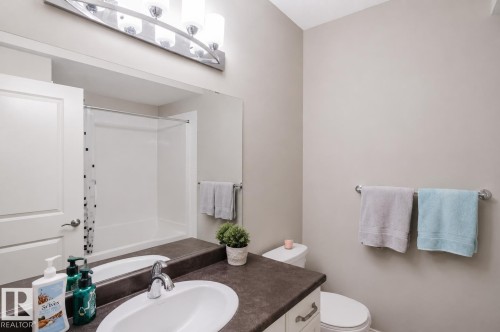 Bathroom vanity featuring a built-in sink and dark countertop - 328 West Haven Drive, Leduc, AB - Indoor Photo Showing Bathroom