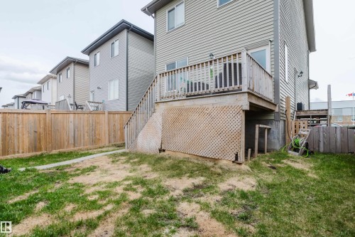 Rear exterior with a wood deck, wood railings, and lattice skirting - 328 West Haven Drive, Leduc, AB - Outdoor With Deck Patio Veranda