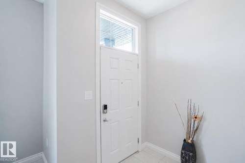 Entryway featuring a white paneled door with a transom window, digital lock, and light gray wall paint - 328 West Haven Drive, Leduc, AB - Indoor Photo Showing Other Room