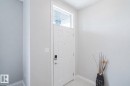 Entryway featuring a white paneled door with a transom window, digital lock, and light gray wall paint - 328 West Haven Drive, Leduc, AB  - Indoor Photo Showing Other Room 