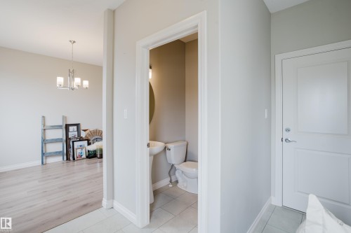 Entryway featuring light gray walls, a white paneled door with brushed nickel hardware, and tile flooring - 328 West Haven Drive, Leduc, AB - Indoor