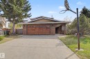 Brick exterior featuring a wood-panel garage door and an arched entryway - 11617 26 Avenue, Edmonton, AB  - Outdoor 