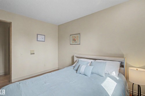 Neutral-toned walls complement wood-finish flooring - 11617 26 Avenue, Edmonton, AB - Indoor Photo Showing Bedroom