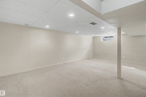 Spacious room featuring neutral carpeting, light-toned walls, and a drop ceiling with recessed lighting - 11617 26 Avenue, Edmonton, AB - Indoor Photo Showing Basement