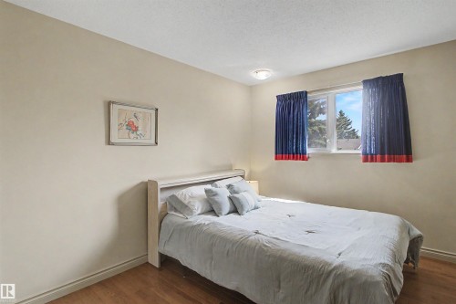 Bright room featuring light beige walls and wood-finish flooring - 11617 26 Avenue, Edmonton, AB - Indoor Photo Showing Bedroom