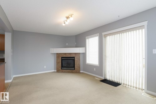 Living area featuring a fireplace with a tiled surround and white mantel - 9071 Scott Crescent, Edmonton, AB - Indoor Photo Showing Living Room With Fireplace