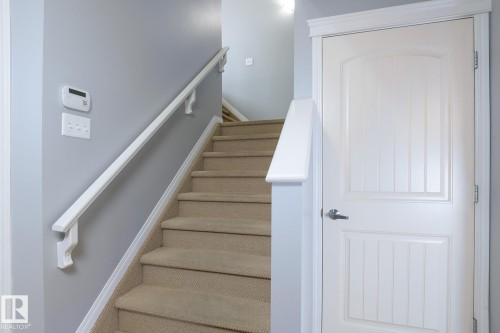 Carpeted staircase with white handrail and light gray wall - 9071 Scott Crescent, Edmonton, AB - Indoor Photo Showing Other Room