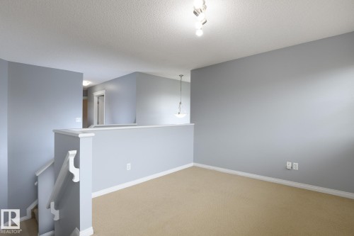 Open loft area featuring neutral carpeting and light gray walls - 9071 Scott Crescent, Edmonton, AB - Indoor Photo Showing Other Room