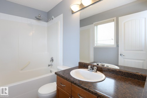 Bathroom featuring a vanity with dark countertop, undermount sink, and chrome faucet - 9071 Scott Crescent, Edmonton, AB - Indoor Photo Showing Bathroom