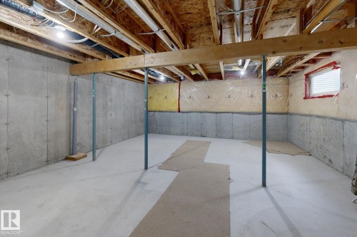 Unfinished basement featuring concrete walls and flooring, exposed ceiling joists, and a horizontal window with blinds - 9071 Scott Crescent, Edmonton, AB - Indoor Photo Showing Basement