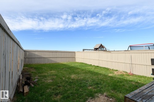 Fenced yard featuring a grass lawn and a sturdy perimeter fence - 9071 Scott Crescent, Edmonton, AB - Outdoor
