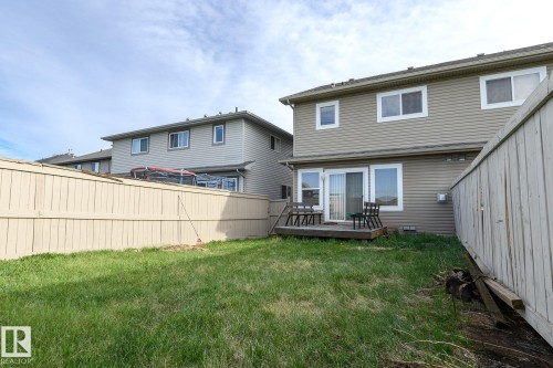 Expansive backyard featuring a manicured lawn, full privacy fencing, and a wooden deck - 9071 Scott Crescent, Edmonton, AB - Outdoor With Deck Patio Veranda With Exterior