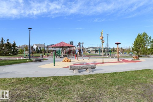 Community park space featuring a large play structure, covered picnic area, and multiple splash pad features - 9071 Scott Crescent, Edmonton, AB - Outdoor With View