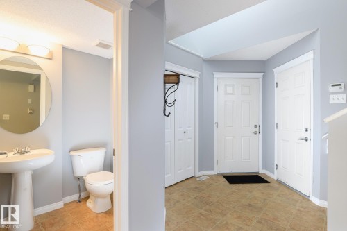 Foyer with light blue walls and brown tile flooring - 9071 Scott Crescent, Edmonton, AB - Indoor Photo Showing Bathroom