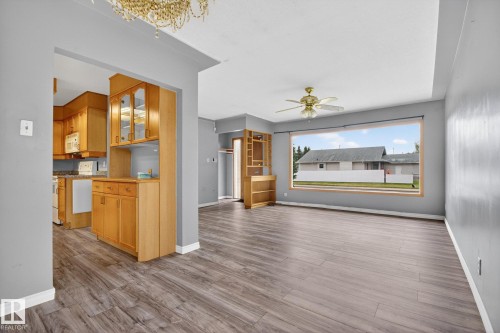 Spacious living area featuring wood-finish flooring, a large picture window, and a ceiling fan - 11901 42 Street, Edmonton, AB - Indoor