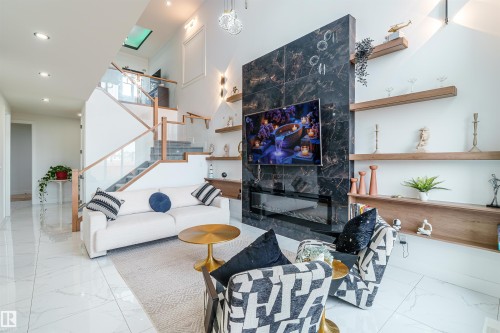 Living area featuring a floor-to-ceiling accent wall with a built-in linear fireplace, integrated television, and a dark stone-look finish - 219 28 Street, Edmonton, AB - Indoor
