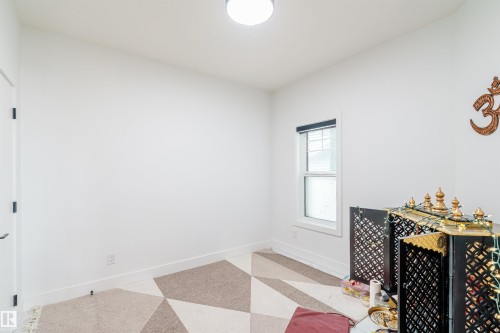 Room featuring a window with a black blind, a flush mount ceiling light, and a white door with black hardware - 219 28 Street, Edmonton, AB - Indoor Photo Showing Other Room