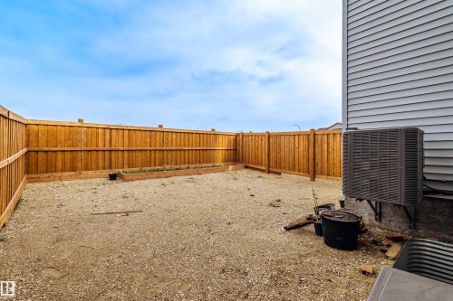Expansive backyard area featuring a new wooden privacy fence, gravel landscaping, and built-in garden beds - 219 28 Street, Edmonton, AB - Outdoor