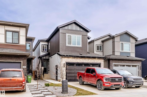 Modern two-story home featuring a dark gray vertical siding facade and light gray horizontal siding on the lower level - 219 28 Street, Edmonton, AB - Outdoor With Facade