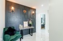 Accent wall with geometric paneling, featuring two wall-mounted sconces and a decorative console table - 219 28 Street, Edmonton, AB  - Indoor Photo Showing Other Room 