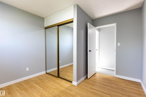 Interior space featuring wood-finish flooring, light grey walls, and white trim - 547 Dunluce Road, Edmonton, AB - Indoor Photo Showing Other Room