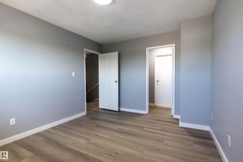 Room featuring wood-finish flooring, light gray walls, white baseboards, and a flush-mount ceiling light - 547 Dunluce Road, Edmonton, AB - Indoor Photo Showing Other Room