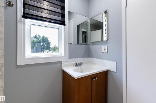 Corner vanity with a white countertop and integrated sink, complemented by a mirrored medicine cabinet - 547 Dunluce Road, Edmonton, AB - Indoor Photo Showing Other Room