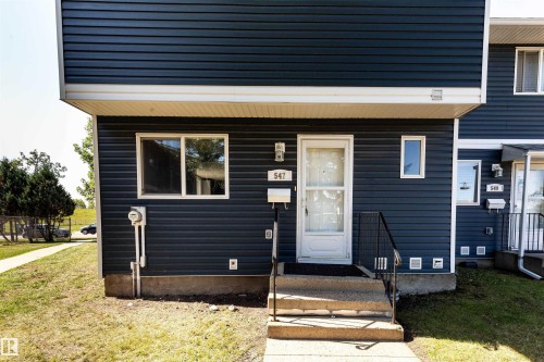 Exterior featuring dark blue horizontal siding with white trim - 547 Dunluce Road, Edmonton, AB - Outdoor With Exterior