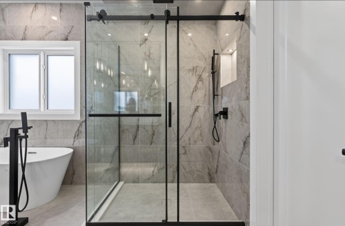 Contemporary shower enclosure with matte black hardware, full-height tile surround, built-in shower niche, and recessed lighting - 5820 110 Street, Edmonton, AB - Indoor Photo Showing Bathroom