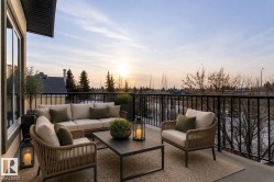 Expansive balcony featuring a black metal railing, concrete flooring, and a large window - 