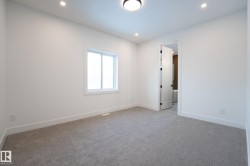 Carpeted room featuring white walls, bright window, recessed lighting, and a white interior door with black hardware - 