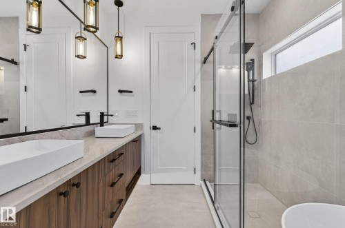 Contemporary bathroom featuring a dual vanity with wood-finish cabinetry and rectangular vessel sinks - 5820 110 Street, Edmonton, AB - Indoor Photo Showing Bathroom