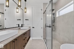 Contemporary bathroom featuring a dual vanity with wood-finish cabinetry and rectangular vessel sinks - 
