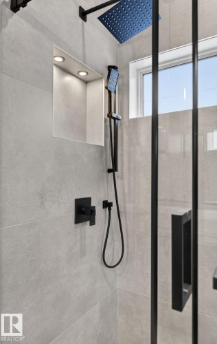 Shower featuring large format light gray wall tiles, a black framed glass enclosure, and a square rain shower head with matching handheld wand - 5820 110 Street, Edmonton, AB - Indoor Photo Showing Bathroom