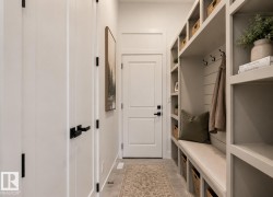 Built-in mudroom organization system featuring open shelving, integrated bench seating, storage cubbies, and coat hooks - 